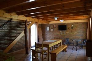 a dining room with a table and chairs and a brick wall at Dunas Norte Departamentos in Balneario El Condor