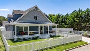 una casa blu con una recinzione bianca di Pet-Friendly Pool Bayside Coastal Cottage a Town Bank