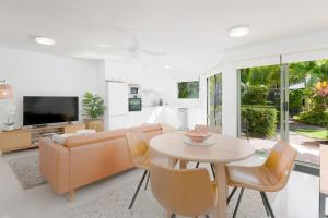 a living room with a couch and a table at Noosa River Retreat Holiday Apartments in Noosaville +157 photos