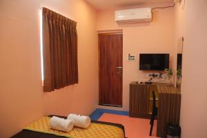a small room with a bed and a television at Tharavaadu by Le Apex in Puducherry