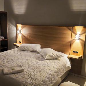 Ponte AltaHouse Hotel e Restaurante的一间卧室，有一张大床，配有两盏灯