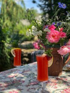 two glasses on a table with a vase of flowers at Villa - Riviera Nistreana in Mălăieşti