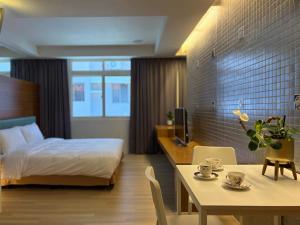 a hotel room with a bed and a table and a dining room at 喃行旅-一房一車位 毛孩友善客房數量有限請先預約 in Tainan +30 photos