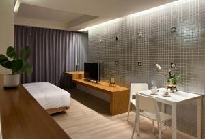 a bedroom with a bed and a desk with a computer at 喃行旅-一房一車位 毛孩友善客房數量有限請先預約-每隻每晚收費500元現場付費 in Tainan
