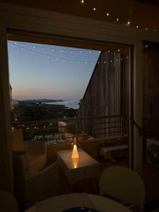 una stanza con una grande finestra con un tavolo e delle sedie di Pied a terre Coralli a Marina di Portisco Altre 2 foto