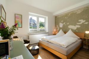 a bedroom with a bed and a window at Pension Perla Sylt in Sylt