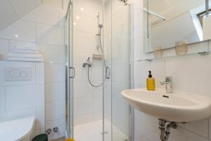 a bathroom with a sink and a shower at Pension Perla Sylt in Sylt +40 photos