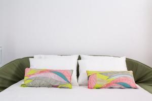 un letto con 4 cuscini e una parete bianca di Deluxe Mykonos Villa Outdoor Pool Villa Del Sol Sea & Pool View 2 Bdr Ornos a Ornos