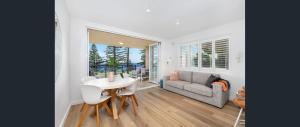 a living room with a table and a couch at Beachfront Getaway in Sydney