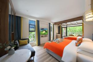 una camera da letto con un letto arancione e bianco e un divano di Guilin O-LIVE Social Hotel -Riverside -Adjacent Elephant Hill -Pedestrian Street-Twin Towers-Mediterranean style a Guilin