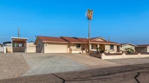 a house with a palm tree in a driveway at Havasu Coral Sun Pool Garage RV Parking in Lake Havasu City
