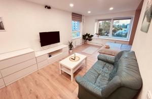a living room with a couch and a tv at Valmiera Stay Apartment in Valmiera