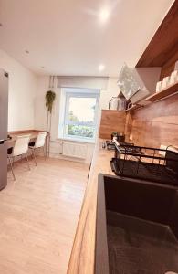 ヴァルミエラにあるValmiera Stay Apartmentのカウンターとテーブルと椅子のあるキッチン