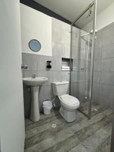 Un baño con inodoro, lavabo y ducha. en Casa La 35, en Medellín