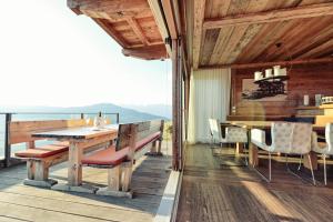 a dining room with a table and chairs on a deck at Maierl-Alm & Maierl-Chalets in Kirchberg in Tirol