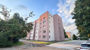 a pink building on the side of a street at Valmiera Stay Apartment in Valmiera