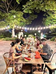 a group of people sitting at a table eating food at Orestay Garden Hạ Long in Ha Long