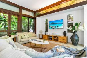 a living room with a couch and a table at Belle Escapes Pura Palm Cove - Two luxury Balinese villas in Palm Cove