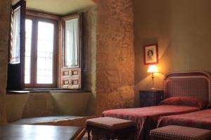 a room with two beds and a window at Casa Palacio Conde de Garcinarro in Huete