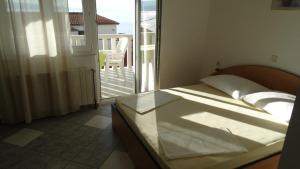 um quarto com uma cama e vista para uma varanda em D&N Urlicic em Omiš