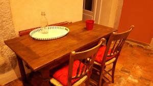 a wooden table with a bottle and a plate on it at Les Tomettes in Dole