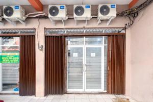 a facade of a building with multiple monitors on the wall at Guest House 21 RedPartner in Jakarta +9 photos