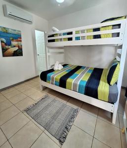 una camera con 2 letti a castello e pavimento piastrellato di Cozy apartment walking distance Tamarindo Beach a Tamarindo