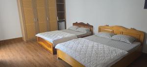 a bedroom with two beds and a closet at Motel 108 in Buon Ma Thuot +11 photos