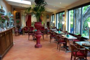 a restaurant with tables and chairs and a plant at La Ferme Rose-Hôtel de Charme in Moustiers-Sainte-Marie