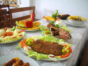 a table topped with plates of food with meat and vegetables at Hotel Casa Vieja in Santa Marta