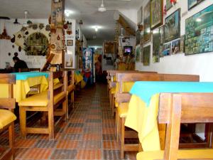 a restaurant with wooden tables and chairs in a room at Hotel Casa Vieja in Santa Marta