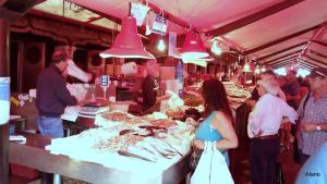 a group of people standing around a market with food at Mon Refuge Villa Deluxe in Correzzola