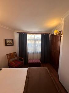 a bedroom with a bed and a chair and a window at Emine Sultan Hotel in Istanbul