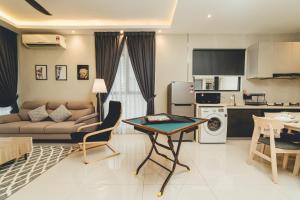 une cuisine et un salon avec une table et un canapé dans l'établissement Danga Bay Family CrestJoy 3BR 6pax Balcony by Our Stay, à Johor Bahru