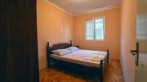 a bedroom with a bed in a room with a window at Apartments Pax in Herceg-Novi