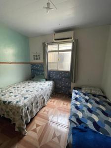ein Schlafzimmer mit zwei Betten und einem Fenster in der Unterkunft Casa com 3 quartos in Belém