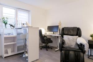 an office with a chair and a desk with a computer at Relax-Apartment 2 mit Massagesessel, Smart-TV und Küche in Biberach an der Riß