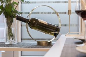 a bottle of wine sitting on a table next to a vase at Relax-Apartment 2 mit Massagesessel, Smart-TV und Küche in Biberach an der Riß +8 photos