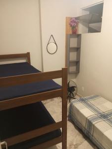 a room with two bunk beds in a room at Kitnet pé na areia in Praia Grande