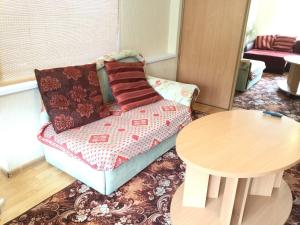 a living room with a couch and a table at Apartment On Oktyabrskaya 4 in Ukhta