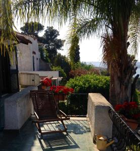 patio z 2 krzesłami i palmą w obiekcie Villa Baia del Riccio w mieście Agnone Bagni