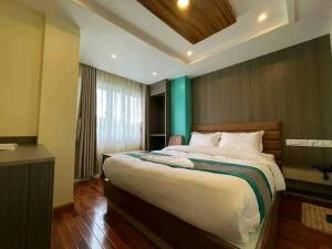 una camera da letto con un letto grande in una stanza di President Hotel Airport a Kathmandu