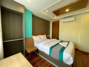 una piccola camera da letto con un letto e una sedia di President Hotel Airport a Kathmandu Altre 2 foto