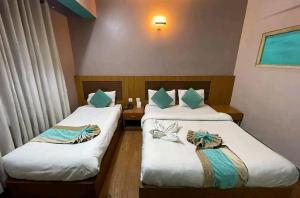 due letti in una camera d'albergo con asciugamani sopra di President Hotel Airport a Kathmandu
