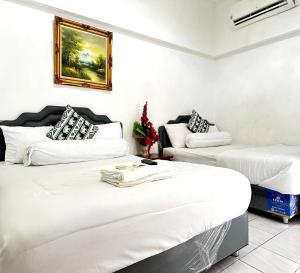 a room with two beds and a couch at ATVR Juldis Tower Pratunam in Bangkok