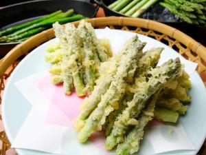 ein weißer Teller mit etwas grünem Spargel darauf in der Unterkunft Hotel Emisia Sapporo in Sapporo