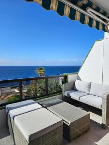 a balcony with a couch and a view of the ocean at Apartment mit Poolsicht in Costa Del Silencio