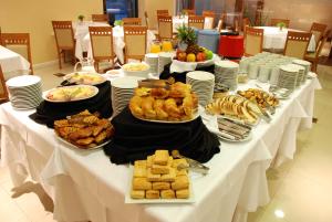 una larga mesa blanca con platos de comida. en Howard Johnson Villa María Hotel y Casino en Villa María