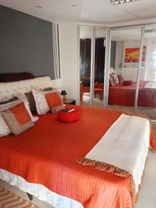 ein Schlafzimmer mit einem großen Bett mit einer orangefarbenen Decke in der Unterkunft Resort Brisa in Ilha do Tatu
