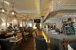 un restaurante con bar, mesas y sillas en Café Orth en Westerland